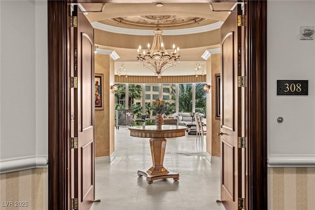 interior space with a notable chandelier, crown molding, and a tray ceiling