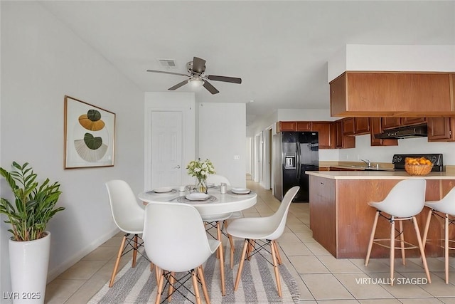 tiled dining area featuring sink and ceiling fan