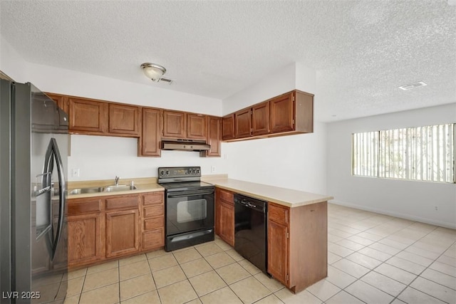 kitchen featuring black appliances, sink, light tile patterned floors, kitchen peninsula, and a textured ceiling