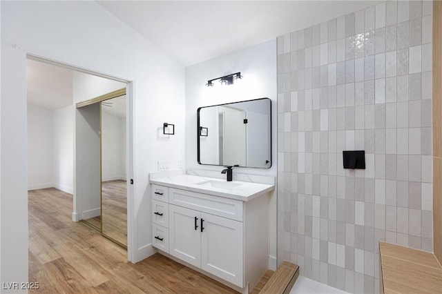 bathroom featuring vanity, hardwood / wood-style floors, and vaulted ceiling