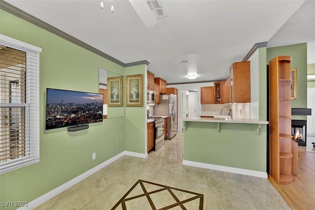 kitchen featuring a breakfast bar area, stainless steel appliances, ornamental molding, decorative backsplash, and kitchen peninsula