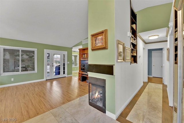 interior space with high vaulted ceiling, french doors, and light wood-type flooring