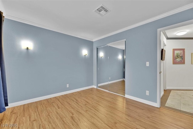 spare room featuring ornamental molding and light wood-type flooring