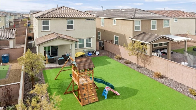 back of house with a playground, a lawn, and a patio area