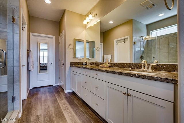 bathroom featuring hardwood / wood-style flooring, vanity, and walk in shower