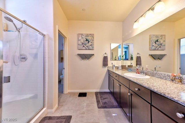 bathroom with tile patterned floors, a shower with shower door, toilet, and vanity