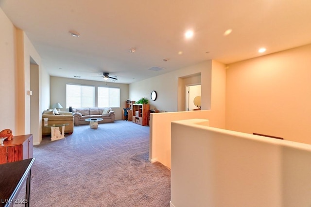 carpeted living room featuring ceiling fan