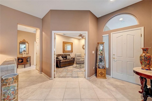 foyer with ceiling fan, baseboards, and light tile patterned floors