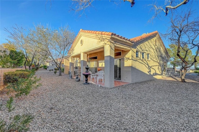 view of home's exterior featuring a patio area, stucco siding, and a tiled roof