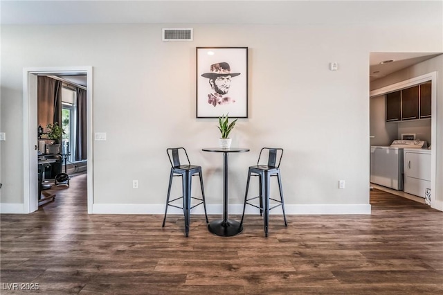 unfurnished dining area featuring washer and clothes dryer and dark wood-type flooring