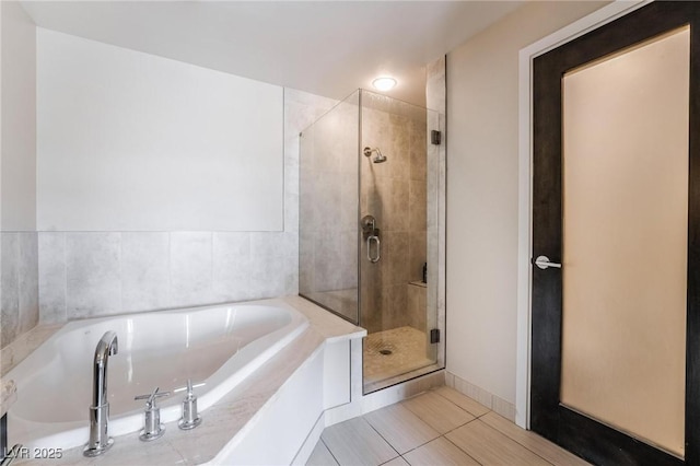 bathroom with independent shower and bath and tile patterned flooring