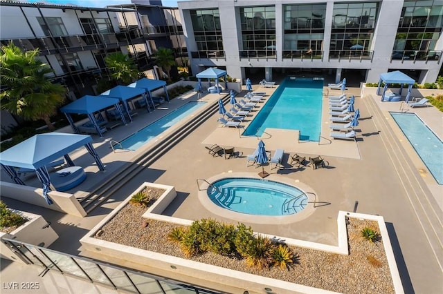 view of pool with a patio and a hot tub