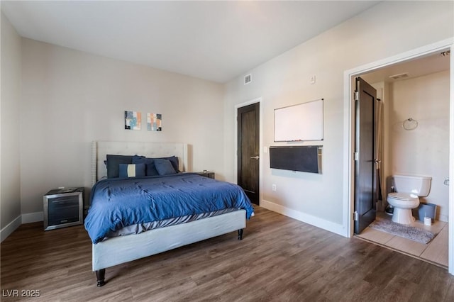 bedroom featuring hardwood / wood-style flooring and connected bathroom