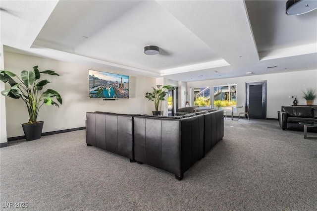 living room with a raised ceiling and carpet flooring