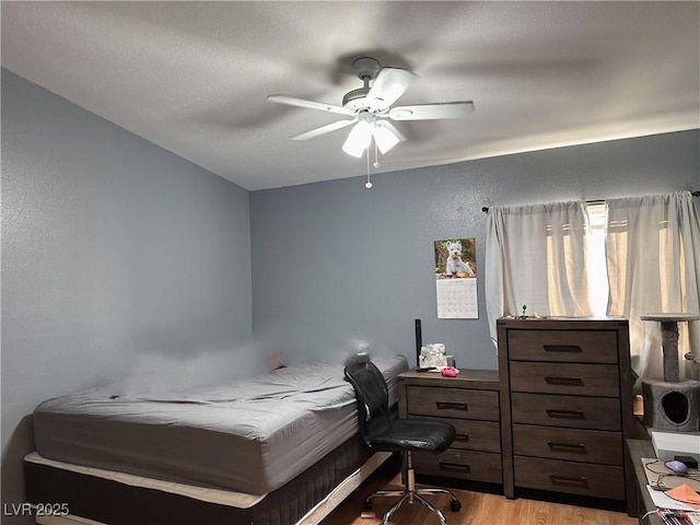 bedroom with light hardwood / wood-style flooring and ceiling fan