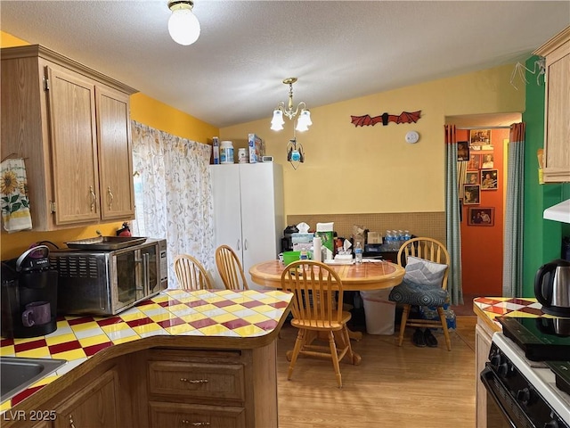 kitchen with a chandelier, decorative light fixtures, light hardwood / wood-style floors, light brown cabinetry, and range