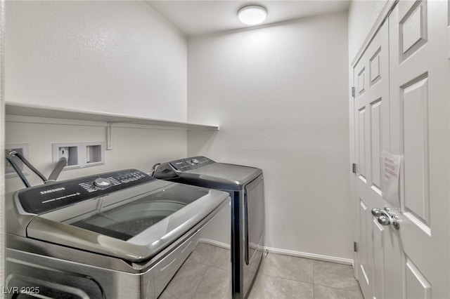 laundry room with washer and clothes dryer and light tile patterned floors