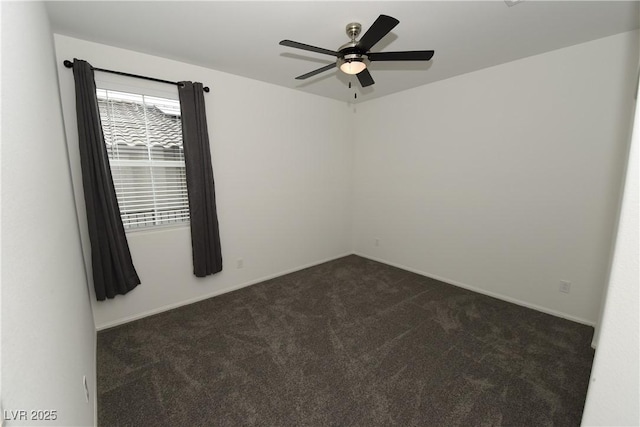 spare room featuring dark carpet and ceiling fan