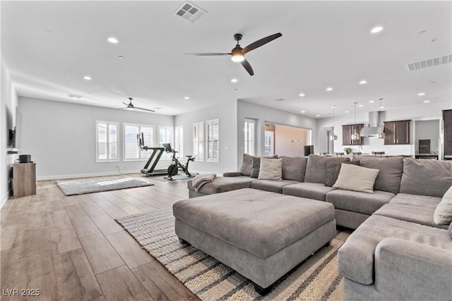 living room featuring light hardwood / wood-style flooring and ceiling fan