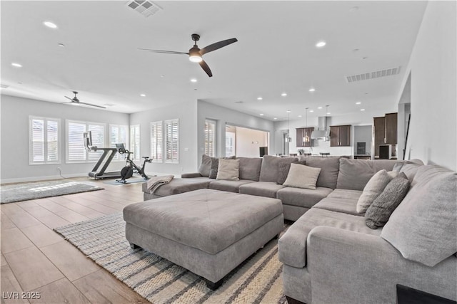 living room featuring light wood-type flooring and ceiling fan