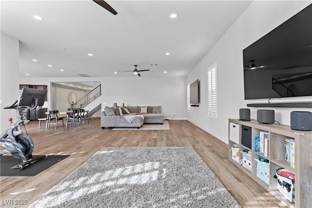 living room featuring ceiling fan and light hardwood / wood-style floors