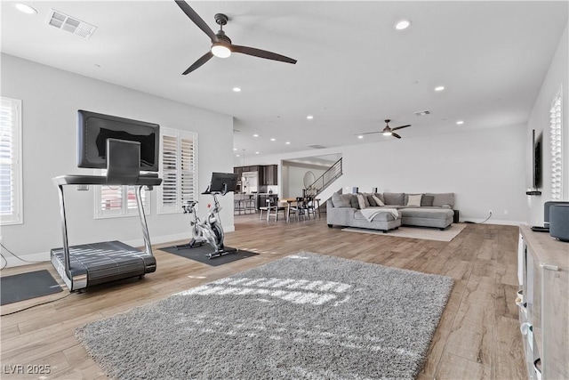 workout area featuring ceiling fan, light hardwood / wood-style floors, and a wealth of natural light