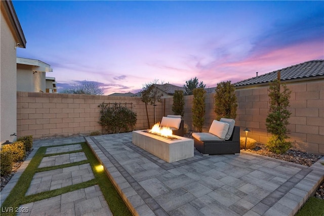 patio terrace at dusk featuring a fire pit