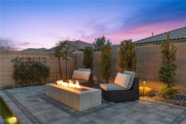 patio terrace at dusk featuring a fire pit