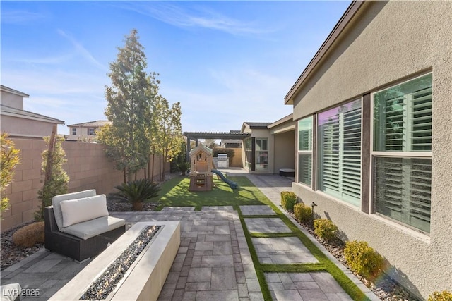 view of yard with a pergola, a playground, and a patio area