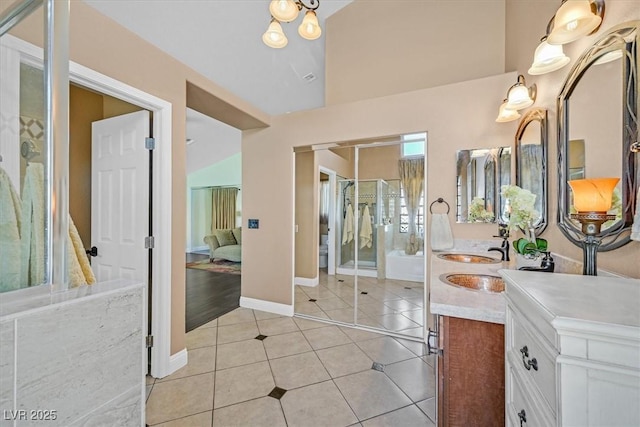 688 Quiet Stream Ct, Henderson, NV 89052 - bathroom featuring double vanity, tile patterned flooring, baseboards, a shower with shower door, and lofted ceiling