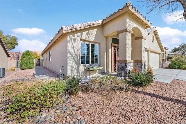 688 Quiet Stream Ct, Henderson, NV 89052 - view of front facade featuring stucco siding, a garage, concrete driveway, a tiled roof, and central AC unit