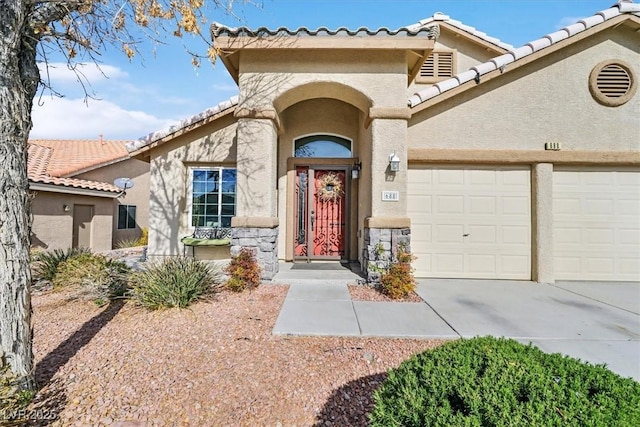 688 Quiet Stream Ct, Henderson, NV 89052 - view of exterior entry with stucco siding, a garage, concrete driveway, and a tile roof