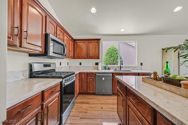 688 Quiet Stream Ct, Henderson, NV 89052 - kitchen featuring stainless steel appliances, a sink, recessed lighting, light wood-style flooring, and light stone countertops