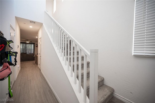 stairway featuring hardwood / wood-style flooring and a high ceiling