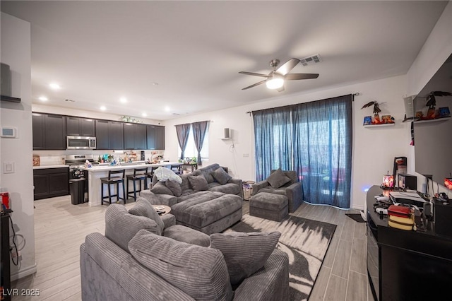 living room with ceiling fan and light hardwood / wood-style floors