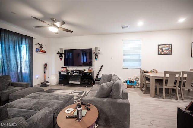 living room featuring ceiling fan and light hardwood / wood-style floors