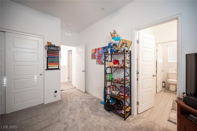 bedroom featuring ensuite bath and light colored carpet