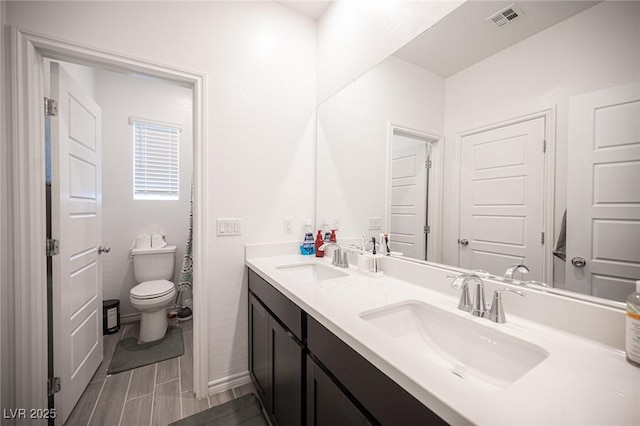 bathroom featuring vanity and toilet