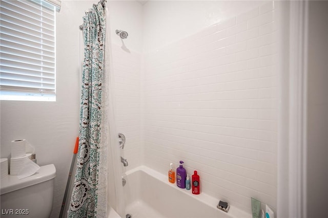 bathroom featuring toilet and shower / bath combination with curtain