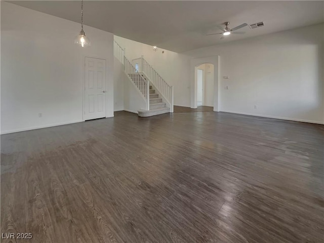 unfurnished living room featuring dark hardwood / wood-style flooring and ceiling fan