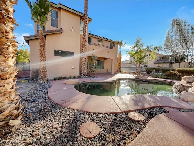 rear view of property with a patio area and a fenced in pool