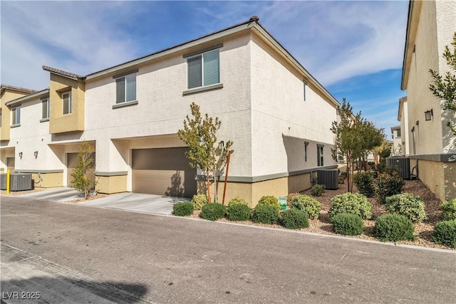 view of front of home with a garage and central AC unit