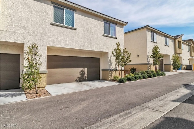 view of property with a garage and central air condition unit