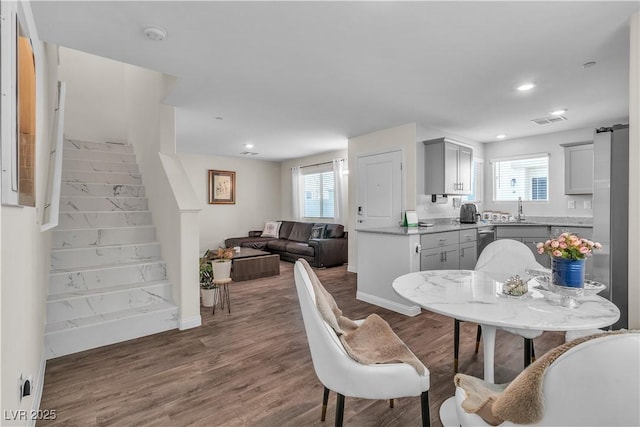 dining area with sink, hardwood / wood-style floors, and a healthy amount of sunlight