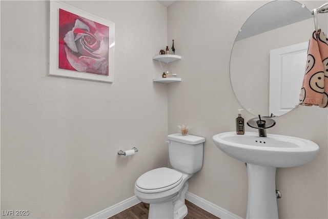 bathroom featuring hardwood / wood-style flooring and toilet