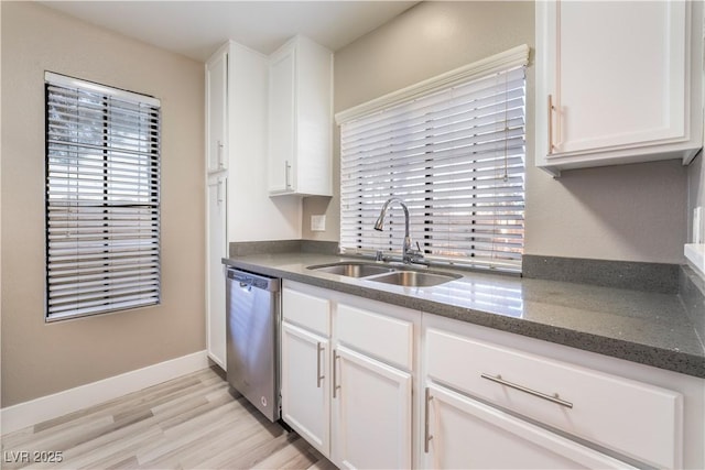 kitchen with sink, dishwasher, white cabinetry, and light hardwood / wood-style flooring