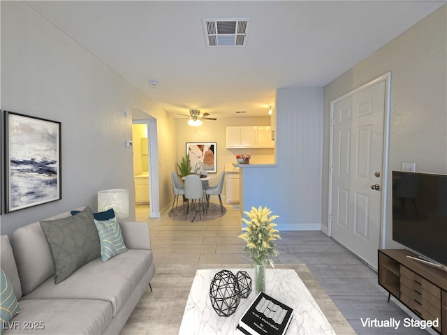 living room featuring ceiling fan and light hardwood / wood-style flooring