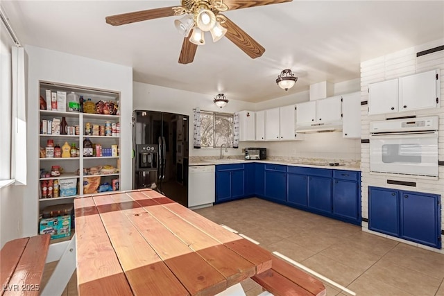 kitchen with blue cabinetry, white cabinetry, black appliances, and sink