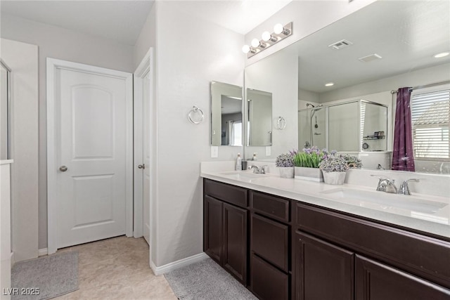 bathroom with an enclosed shower, vanity, and tile patterned floors