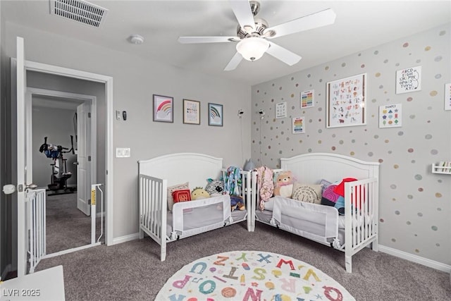 bedroom featuring a crib, carpet, and ceiling fan